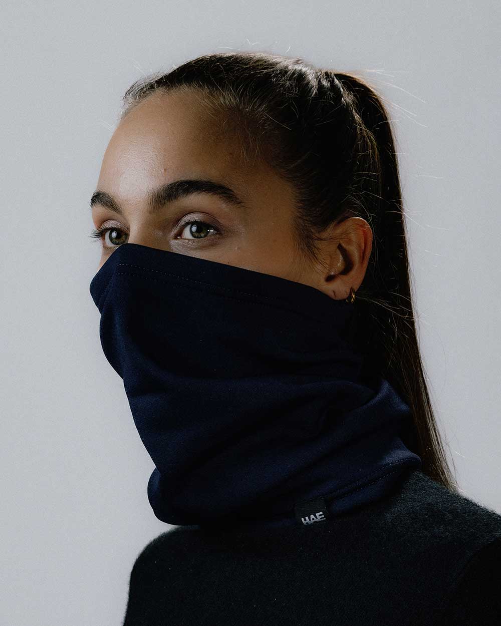 Das weibliche Model präsentiert den Halsschlauch in Blau Navy
