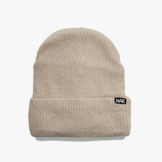 Adventurer 2.0 Mütze von HAE in Offwhite – flauschige Beanie aus 100% Polyamid mit HAE-Label, Produktfoto von vorne