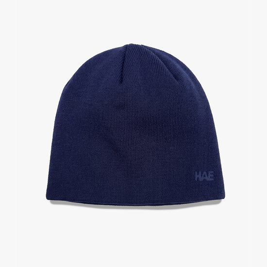 HAE Guide Beanie in Blau (Navy) – schlichte, einfarbige Mütze aus weichem Acryl mit Ton-in-Ton gesticktem HAE Logo, Produktfoto auf weissem Hintergrund