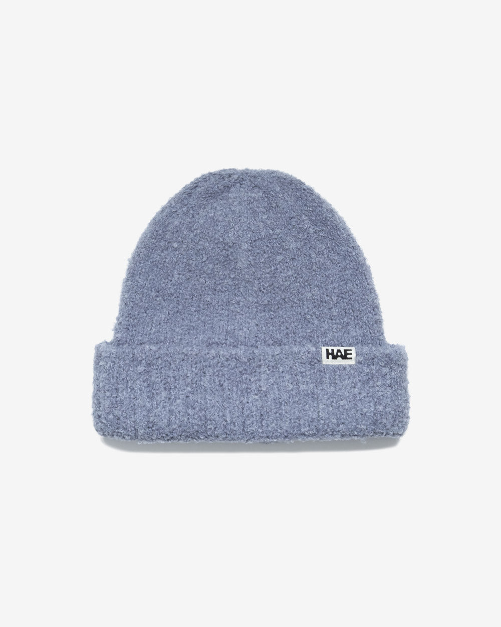 HAE Nomad Beanie in Blau, weiches meliertes Strickmuster mit HAE-Logo-Label, 23% Wolle 59% Acryl 17% Polyamid 1% Elastan, freigestellt vor weissem Hintergrund