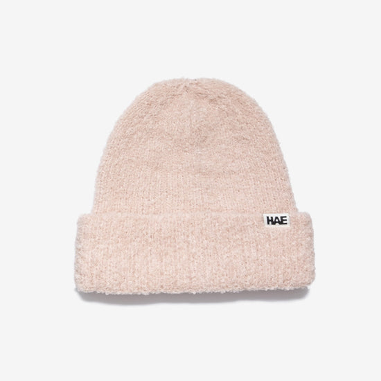 HAE Nomad Beanie in Rose, weiches meliertes Strickmuster mit HAE-Logo-Label, 23% Wolle 59% Acryl 17% Polyamid 1% Elastan, freigestellt vor weissem Hintergrund