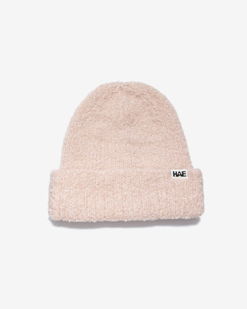 HAE Nomad Beanie in Rose, weiches meliertes Strickmuster mit HAE-Logo-Label, 23% Wolle 59% Acryl 17% Polyamid 1% Elastan, freigestellt vor weissem Hintergrund