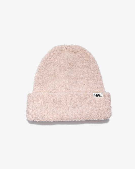 HAE Nomad Beanie in Rose, weiches meliertes Strickmuster mit HAE-Logo-Label, 23% Wolle 59% Acryl 17% Polyamid 1% Elastan, freigestellt vor weissem Hintergrund