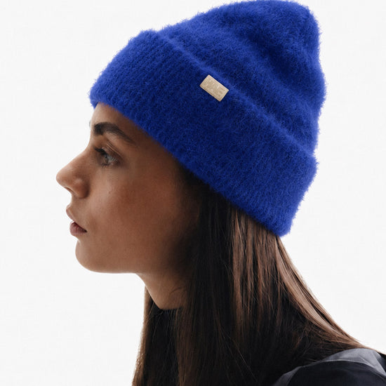 Frau trägt die Adventurer 2.0 Mütze von HAE in Blau seitlich im Profil – flauschige Beanie aus 100% Polyamid