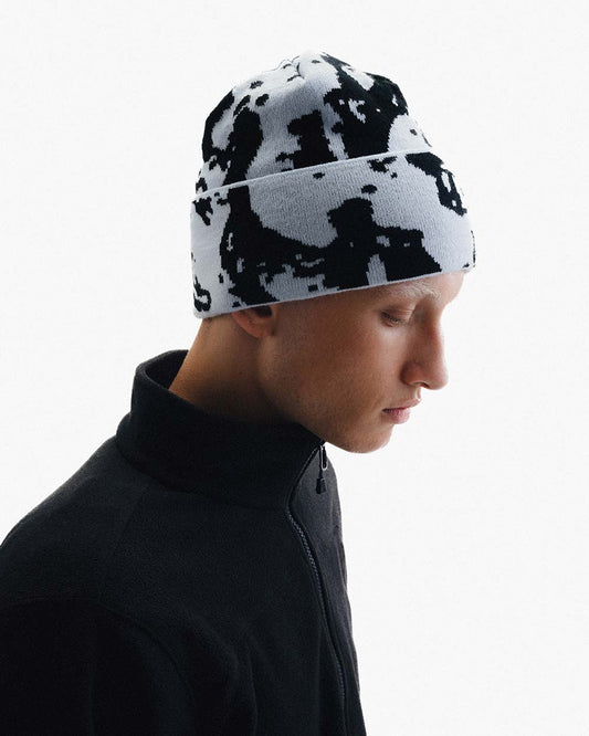 HAE Faceshot Beanie in Illusion Blue am Model getragen, zweifarbiges Splatter-Muster in Schwarz und Weiss, 100% Acryl