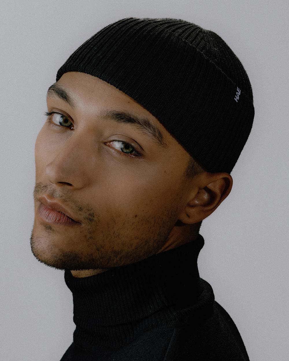 Das männliche Model präsentiert das Beanie Protector in Schwarz