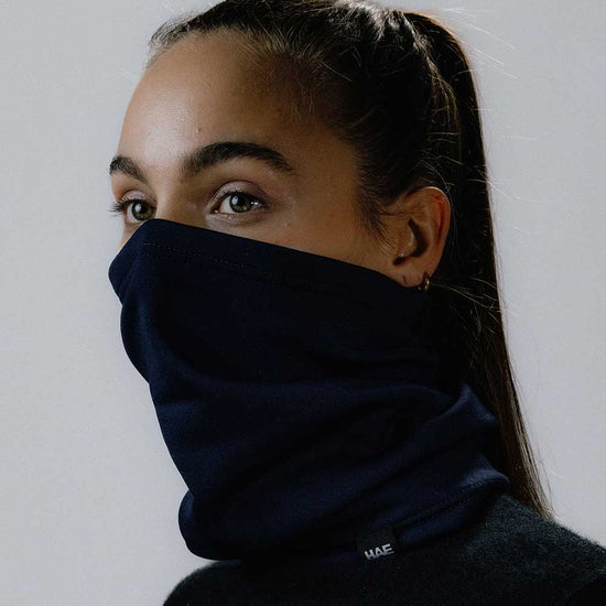Das weibliche Model präsentiert den Halsschlauch in Blau Navy