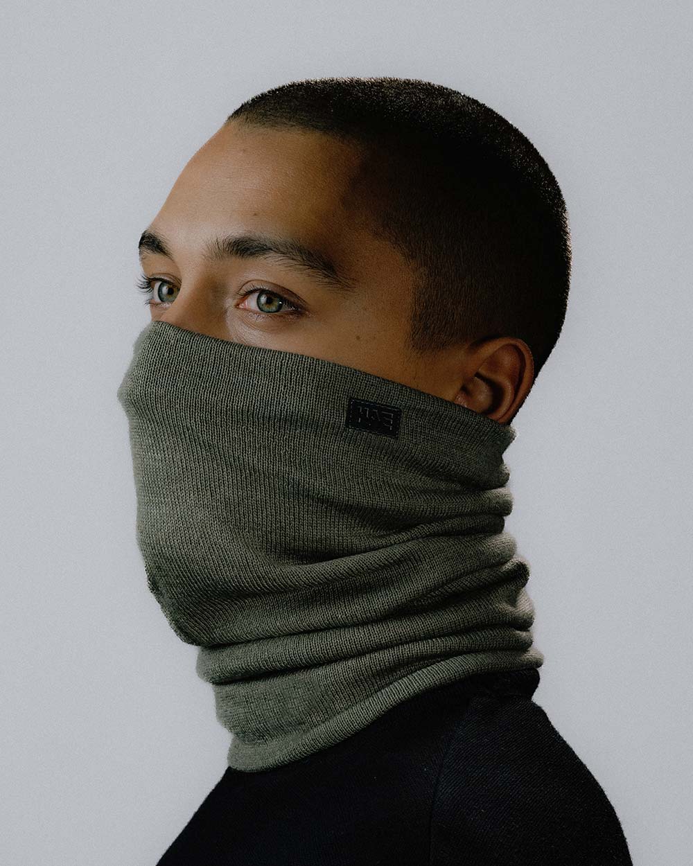 Das männliche Model zeigt den Drifter Neckwarmer und wie man ihn tragen sollte